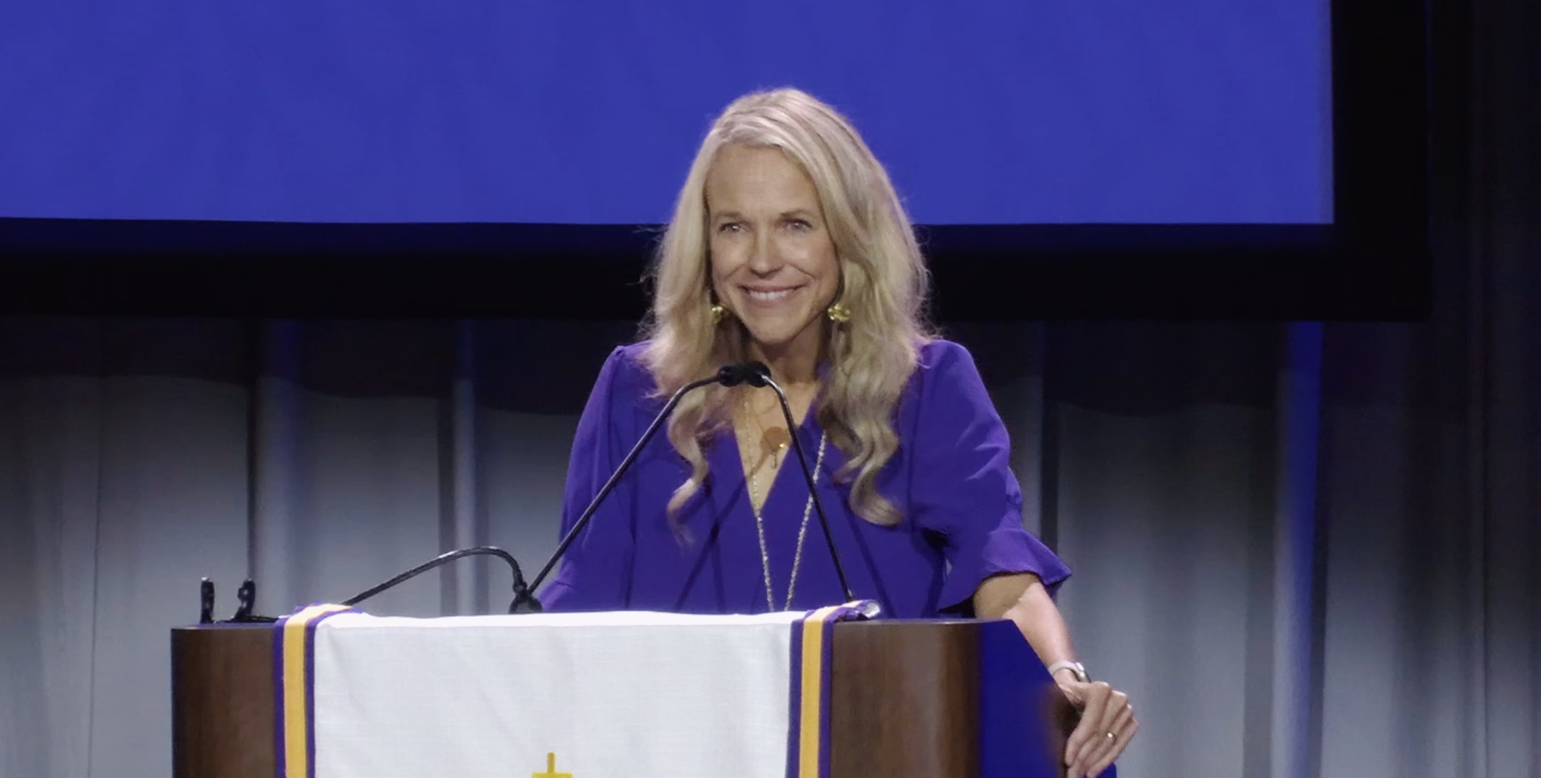 Main About Christina Hergenrader speaking at podium